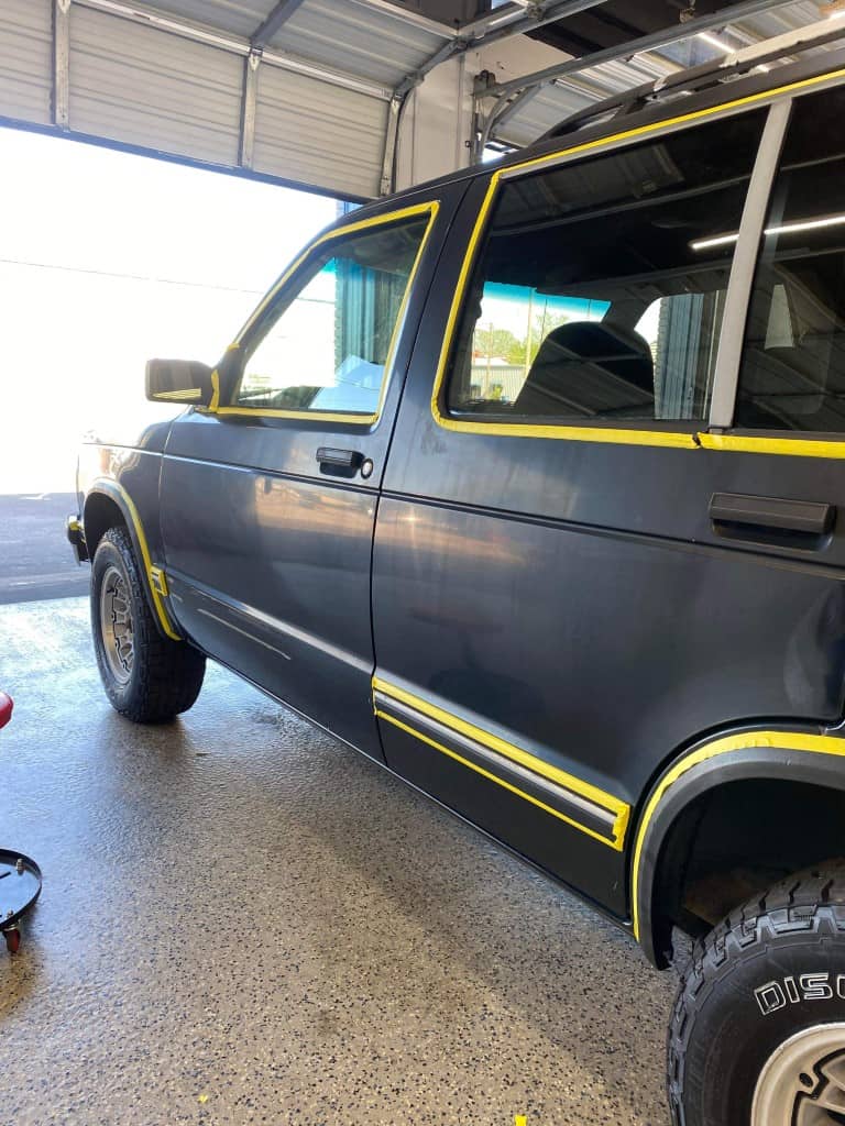 a parked suv inside a workshop with sunlight streaming in.